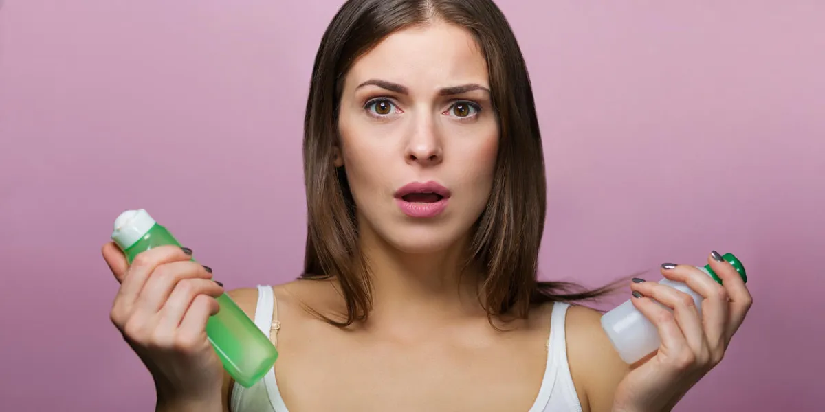 pretty woman holding a bottle with a skin care product pretty woman holding a bottle with a skin care product