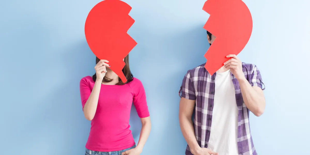 young couple take broken heart isolated on blue background