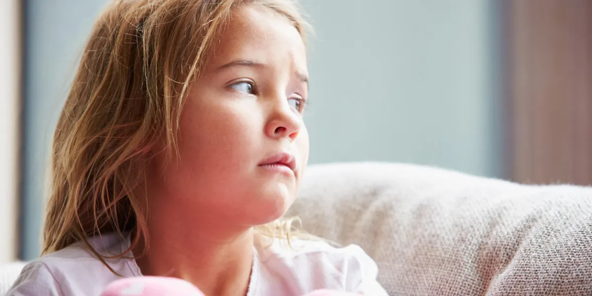 physically abused child at home sitting on sofa