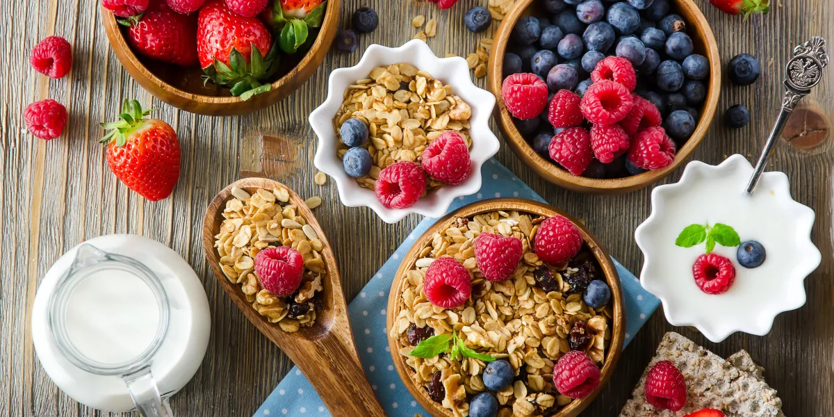 petit déjeuner sain, muesli, framboises, myrtilles, fraises, pain croquant et yogourt, concept de santé et de régime