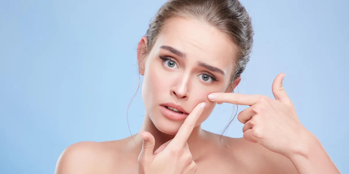 beauty concept, head and shoulders of young woman with natural makeup disappointed girl looking at camera sadly and pressing out pimple on skin studio, indoors beauty concept, head and shoulders of young woman with natural makeup disappointed girl looking at camera sadly and pressing out pimple on skin studio, indoors