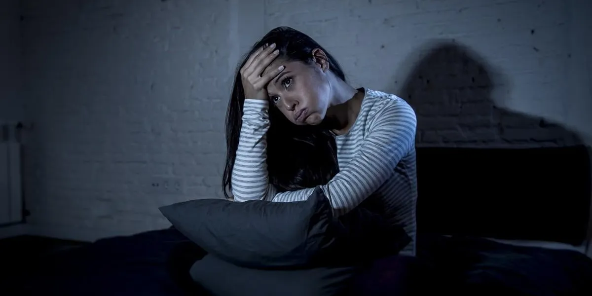 jeune belle femme hispanique à la maison chambre coucher dans son lit tard dans la nuit, essayant de dormir souffrant d'insomnie trouble du sommeil ou effrayé sur les cauchemars à la recherche triste inquiet et stressé