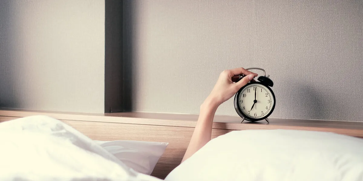 woman sleep on the bed turns off the alarm clock wake up at the morning, selective focus woman sleep on the bed turns off the alarm clock wake up at the morning, selective focus