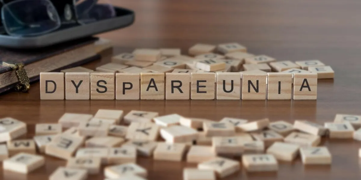 dyspareunia word or concept represented by wooden letter tiles on a wooden table with glasses and a book dyspareunia word or concept represented by wooden letter tiles on a wooden table with glasses and a book