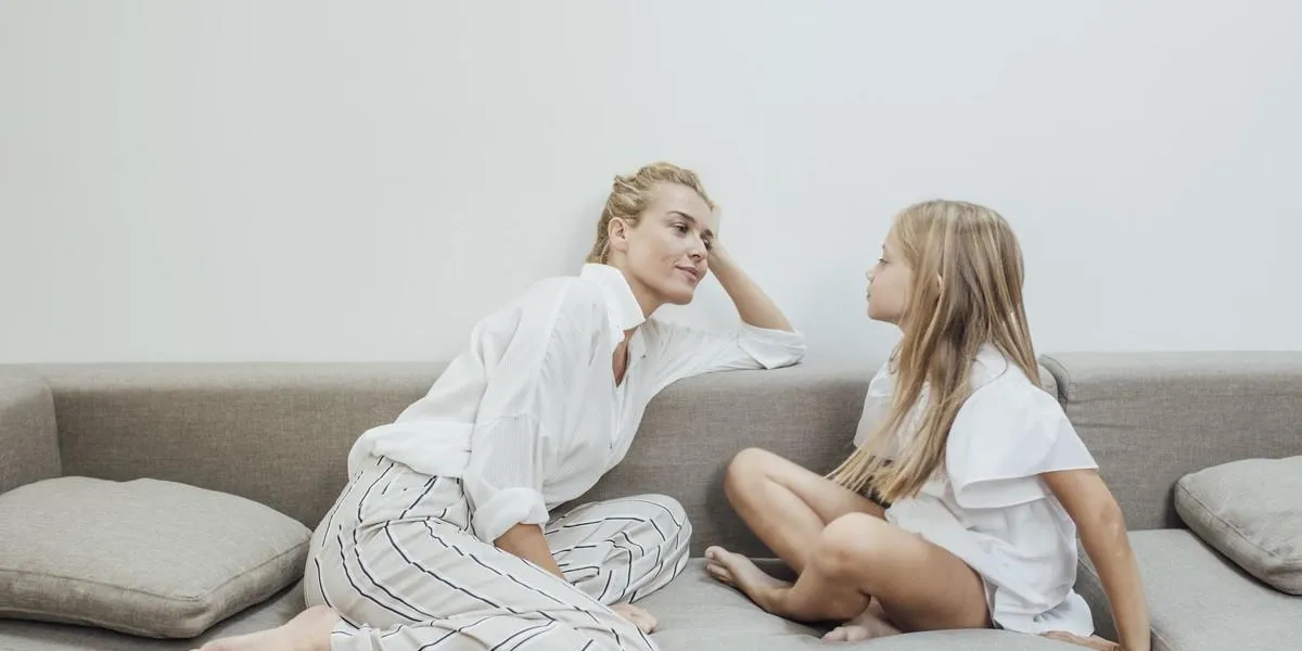 beautiful blonde caucasian smiling woman talking with her cute daughter