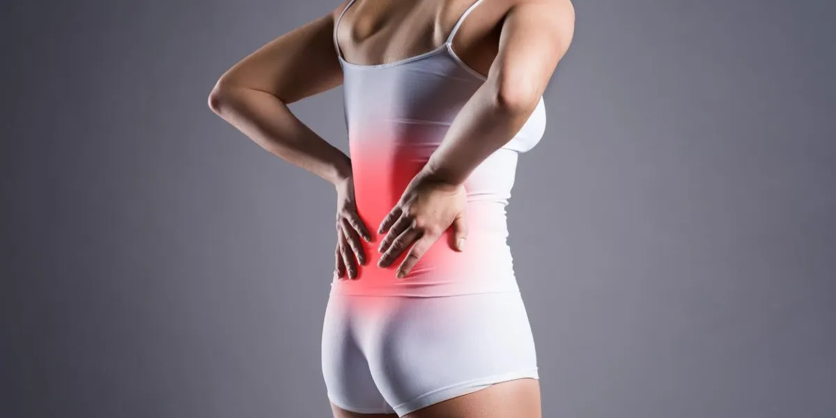 back pain, kidney inflammation, ache in woman's body on gray background back pain, kidney inflammation, ache in woman's body on gray background