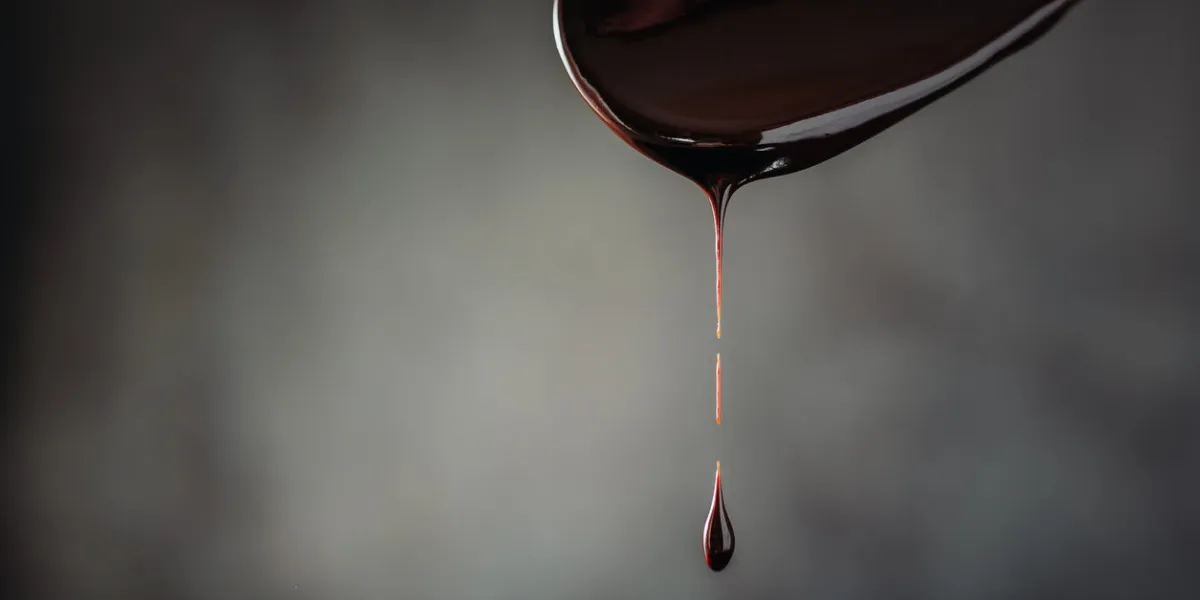 drop of hot chocolate on wooden spoon close up drop of hot chocolate on wooden spoon close up