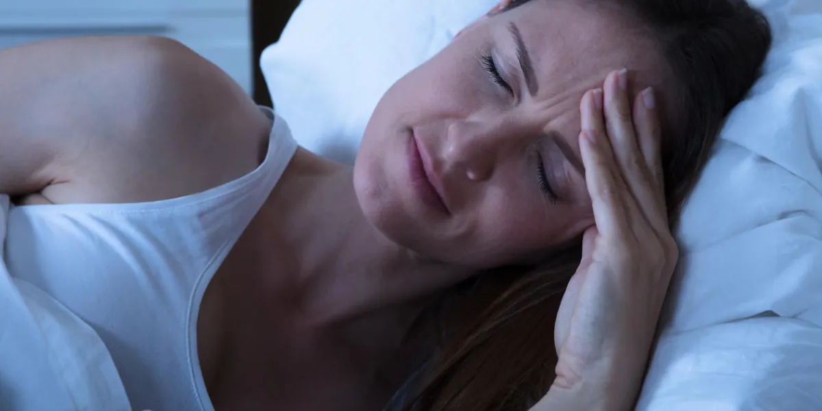 young caucasian woman in bed suffering from a headache young caucasian woman in bed suffering from a headache