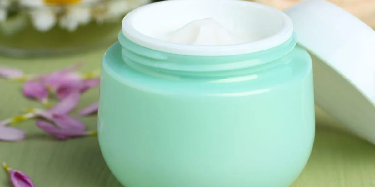 crème pour le visage en plein air avec chrysanthème dans le bol et une serviette sur fond en bois crème pour le visage en plein air avec chrysanthème dans le bol et une serviette sur fond en bois