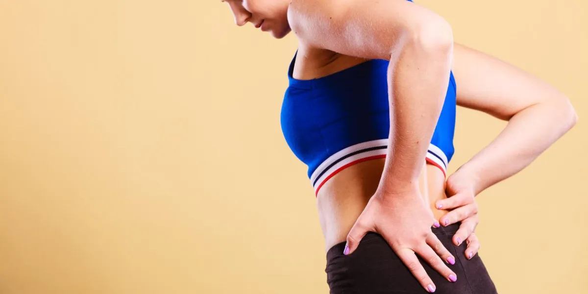 sport training gym and health problem young fit female with backache woman suffering from back pain