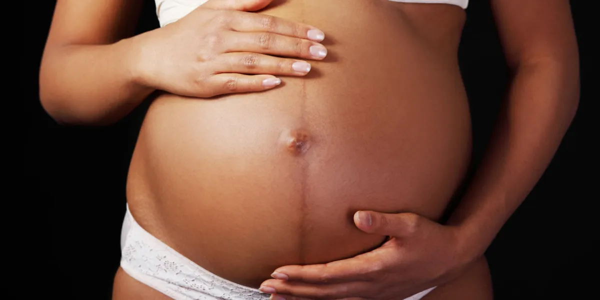 pregnant woman belly over black background