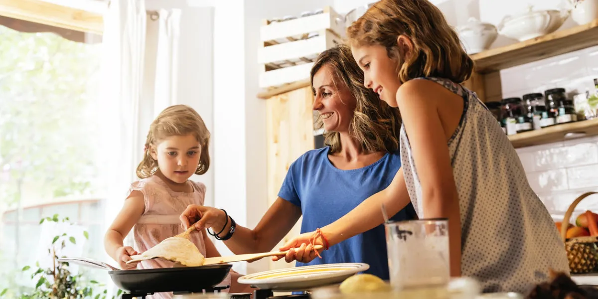 little sisters cooking with her mother in the kitchen infant chef concept