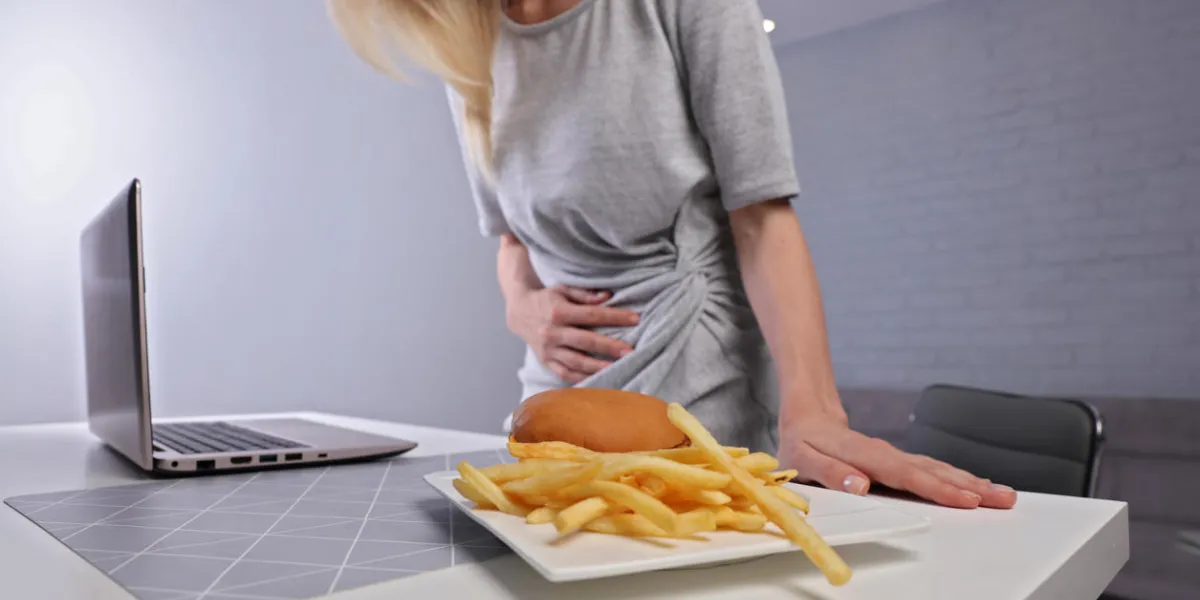 woman having stomachache because of eating unthelthy junk food chronic gastritis or ulcer