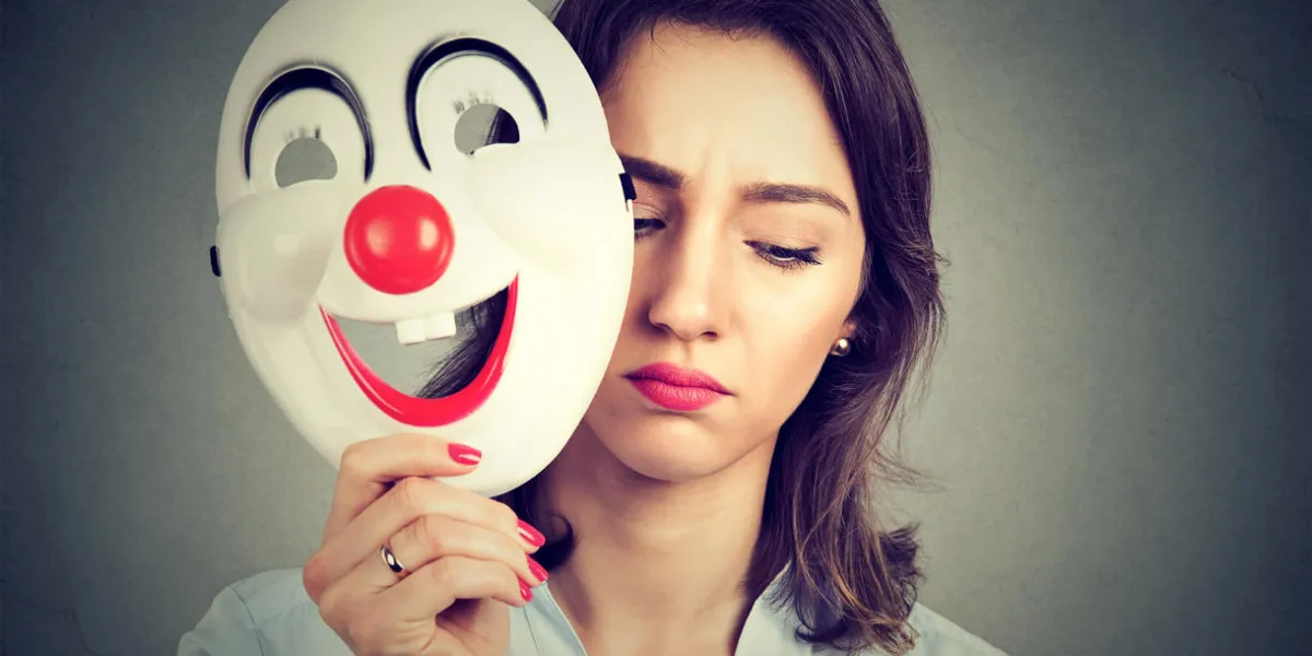 portrait sad woman taking off happy clown mask isolated on gray wall background human emotions feelings portrait sad woman taking off happy clown mask isolated on gray wall background human emotions feelings