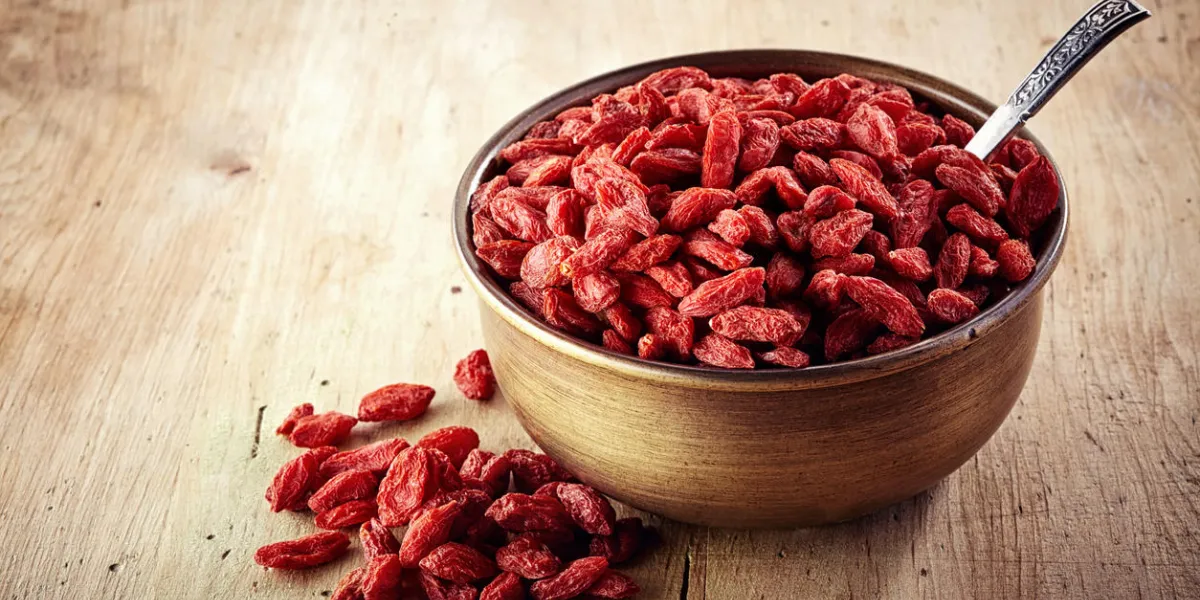 bowl of goji berries on wooden background