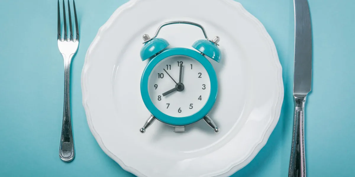 intermittent fastin concept - empty plate on blue background, copy space