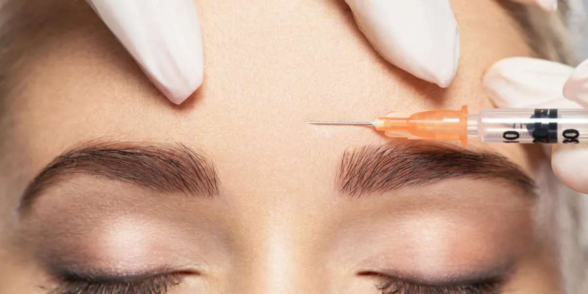 woman getting cosmetic injection of botox near eyes, closup woman in beauty salon plastic surgery clinic
