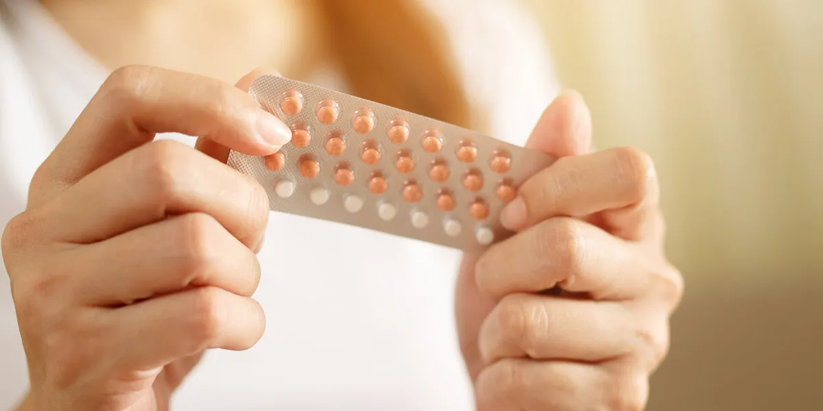 woman hands opening birth control pills in hand eating contraceptive pill contraception reduces childbirth and pregnancy concept
