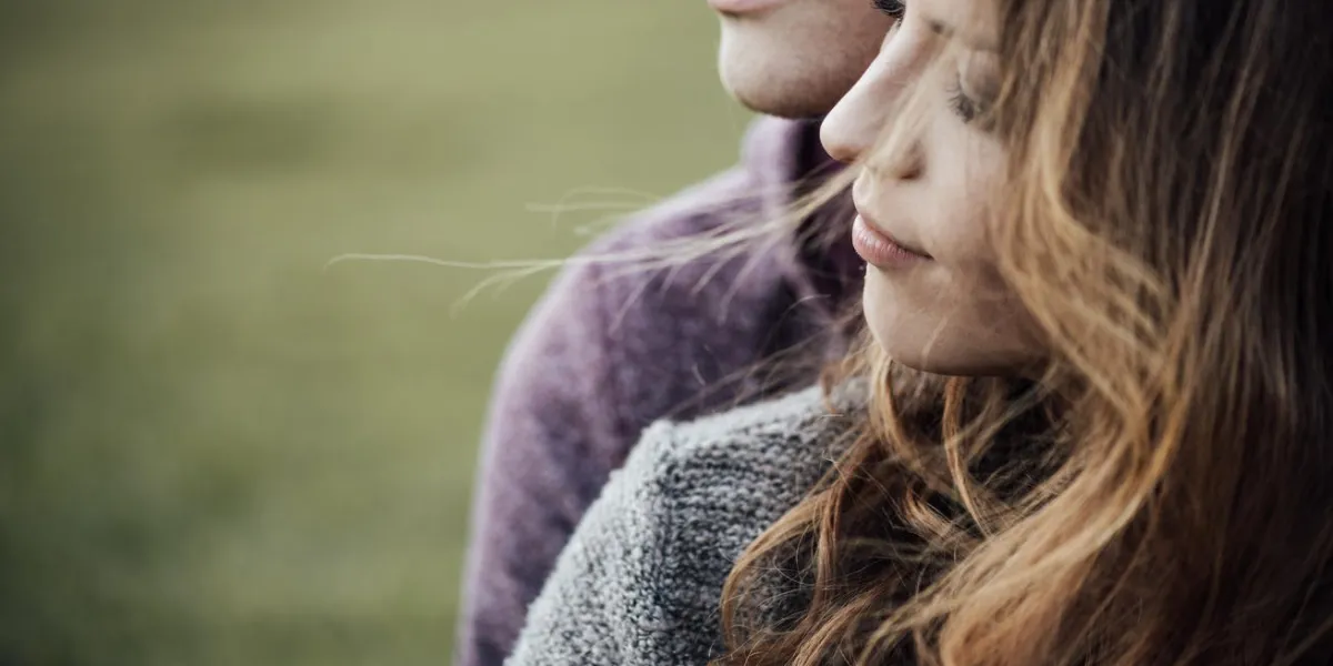 jeune couple d'amoureux à l'extérieur assis sur l'herbe, étreindre et regarder loin, futur et concept de relations jeune couple d'amoureux à l'extérieur assis sur l'herbe, étreindre et regarder loin, futur et concept de relations