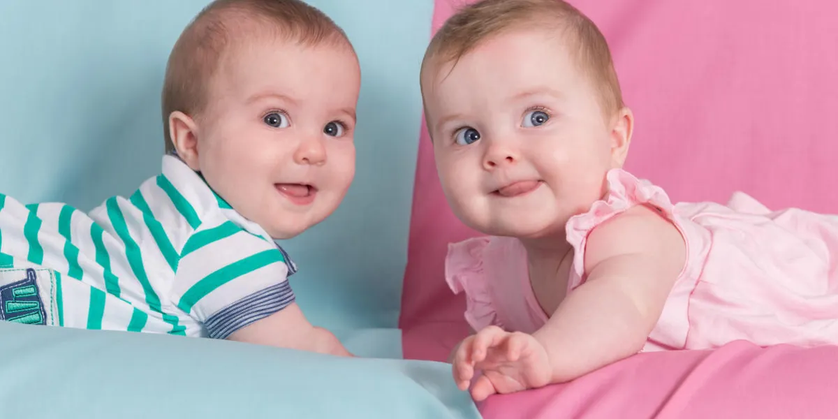brother and sister - twins babies girl and boy on pink and blue background brother and sister - twins babies girl and boy on pink and blue background