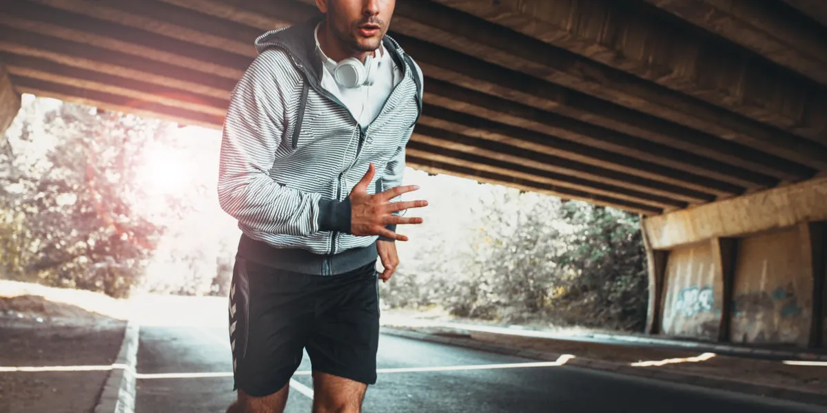coureur masculin jogging dans la ville sous le pont
