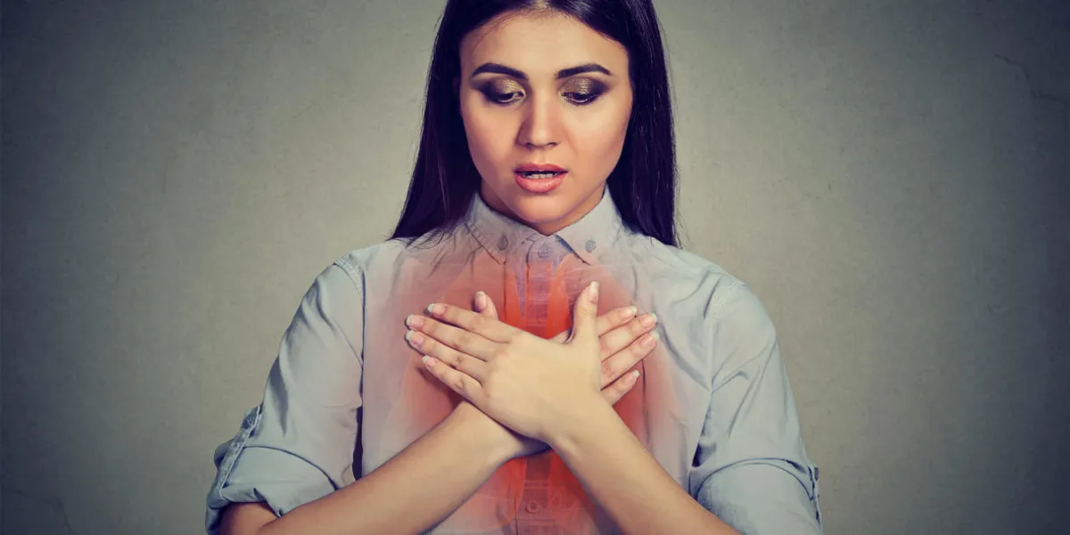 young woman with asthma attack or respiratory problem isolated on gray background