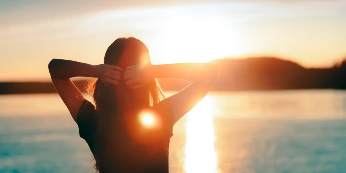 silhouette of a dreamer girl looking hopeful at the horizon