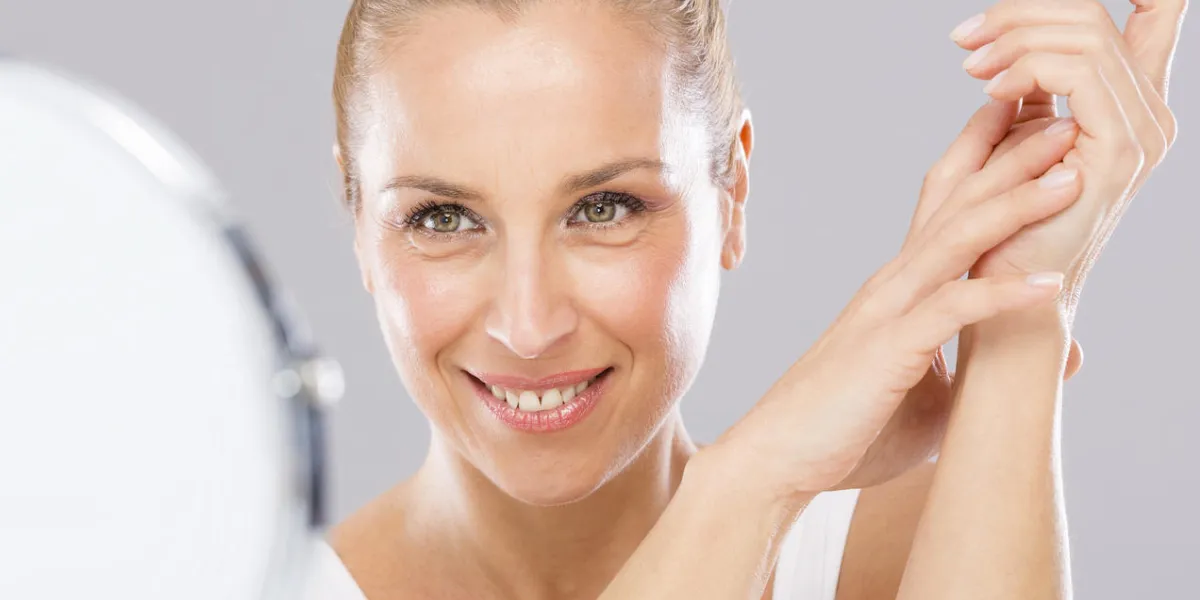 femme d'âge moyen avec tendresse peau de visage regardant vers le miroir
