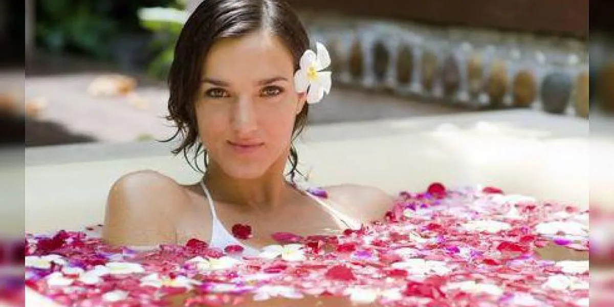 une jeune femme dans un bain avec des pétales et des fleurs
