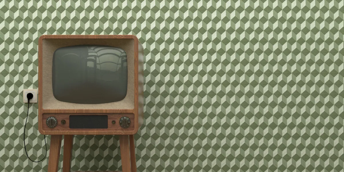 old retro tv in the interior of the living room stands on the parquet floor on a background of a wall with green abstract wallpaper copy space old retro tv in the interior of the living room stands on the parquet floor on a background of a wall with green abstract wallpaper copy space