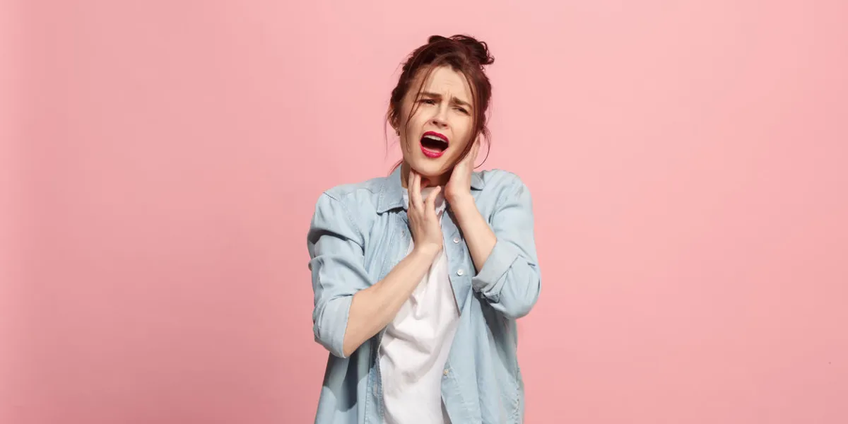 sore ear ear ache concept the sad crying woman with headache or pain on trendy pink studio background facial expressions and people emotions concept front view half-length portrait young woman