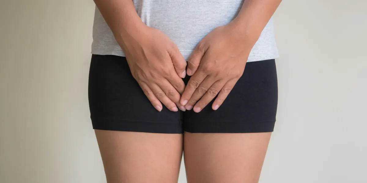woman with hands holding her crotch