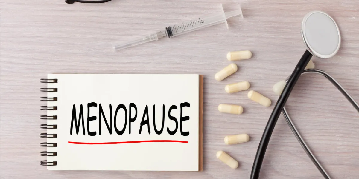 menopause written on notebook with stethoscope, syringe and pills medical concept menopause written on notebook with stethoscope, syringe and pills medical concept