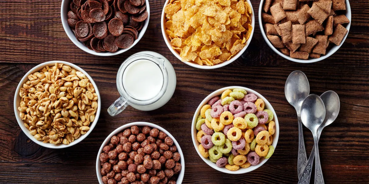 bowls of various cereals and milk from top view