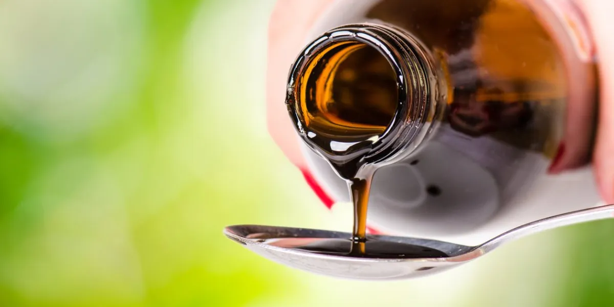 pouring a liquid on a spoon natural green background pharmacy and healthy background medicine cough and cold drug