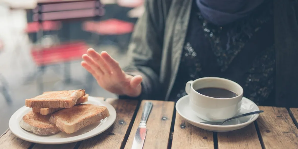 une jeune femme en régime sans gluten dit non grâce au pain dans un café
