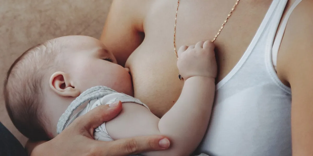 close up young mom breastfeeding newborn baby at home woman nursing baby in bedroom care mother spends her time caring for newborn child concept of motherhood and happy family copy space