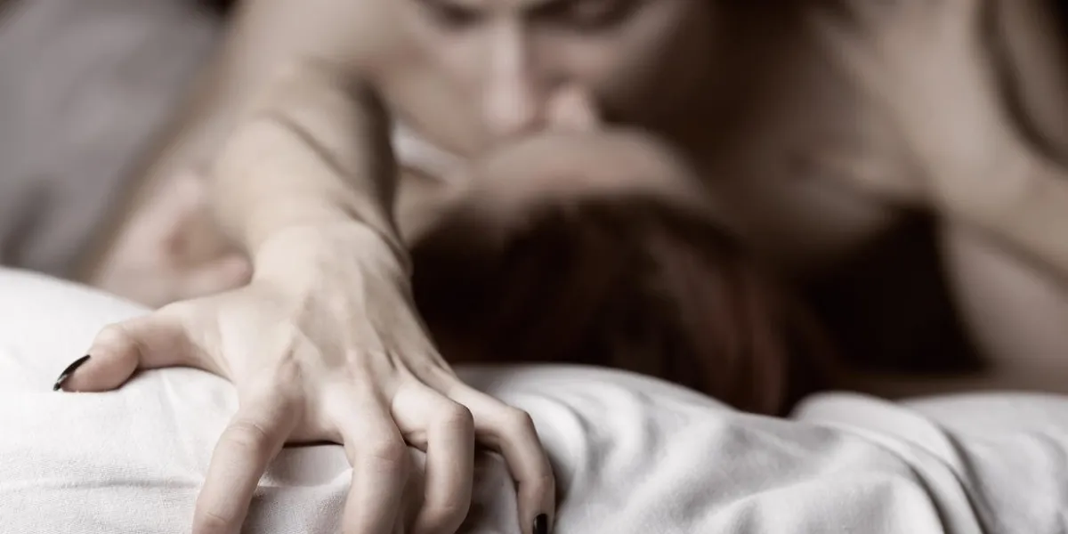 young couple making love in bed focus on hand