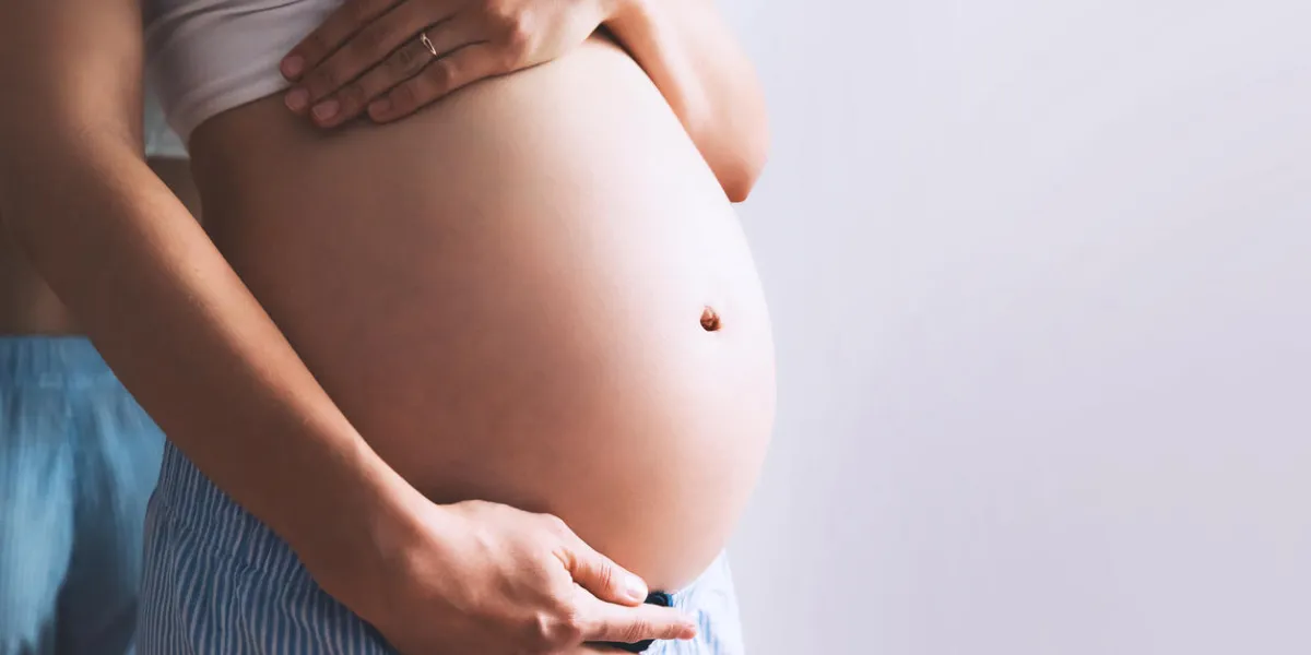 close-up pregnant woman's belly on white background pregnancy, parenthood, preparation and expectation concept