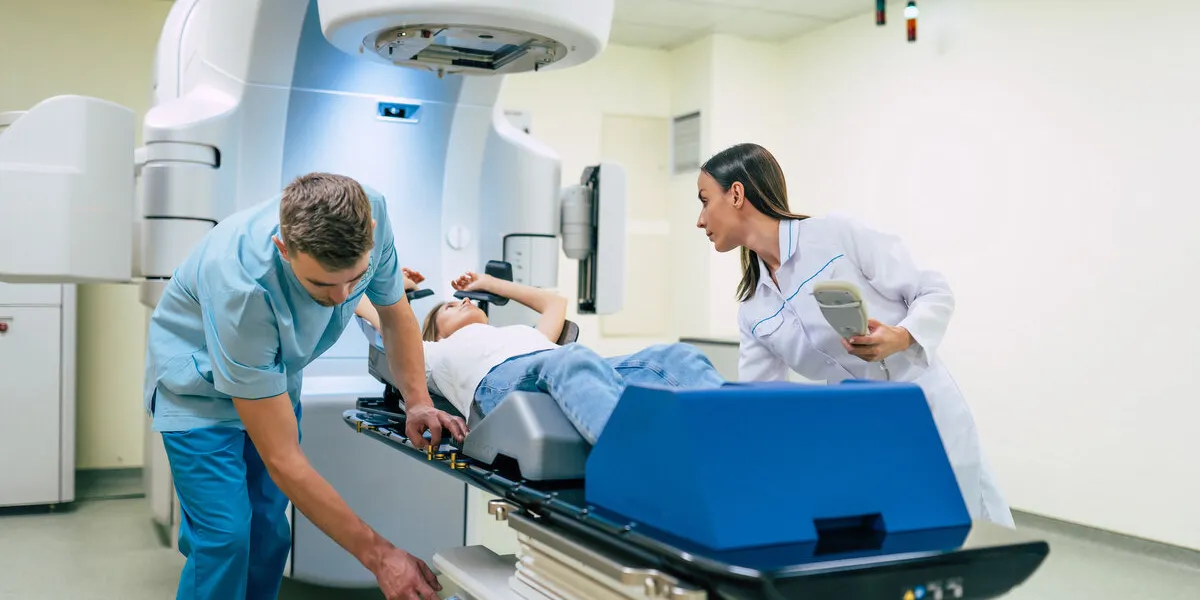 cancer treatment in a modern medical private clinic or hospital with a linear accelerator professional doctors team working while the woman is undergoing radiation therapy for cancer