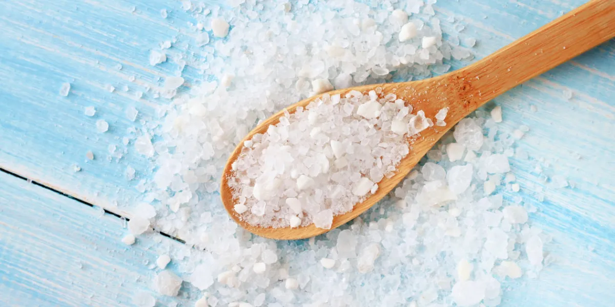 gros grains de sel de mer sur une table bleu clair minable gros grains de sel de mer sur une table bleu clair minable