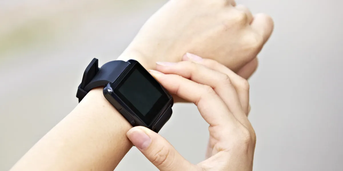 hands of a young female operating a black smart watch