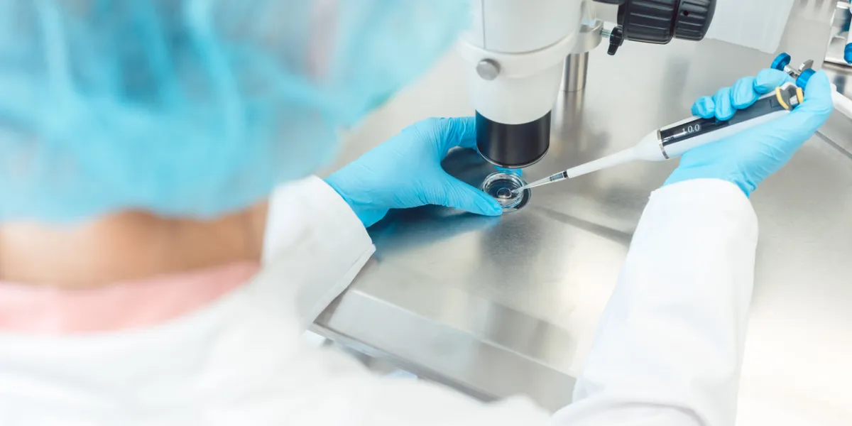 woman scientist working with pipette in laboratory dripping egg cell in solution