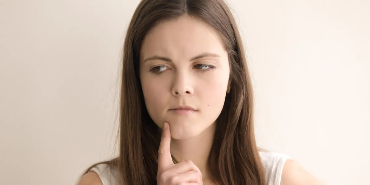 headshot portrait of thoughtful young woman lovely teen girl deeply immersed in thoughts, thinking about problem solving pensive female tensely ponders difficult question close up front view