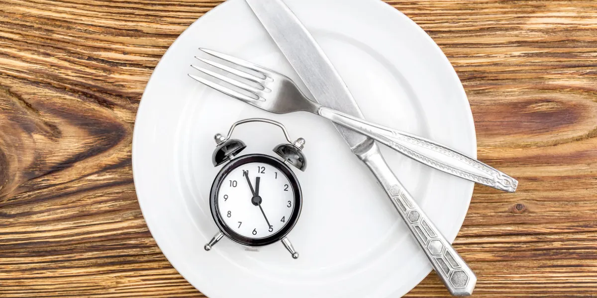 alarm clock with fork, knife and plate on the table top view time to eat alarm clock with fork, knife and plate on the table top view time to eat