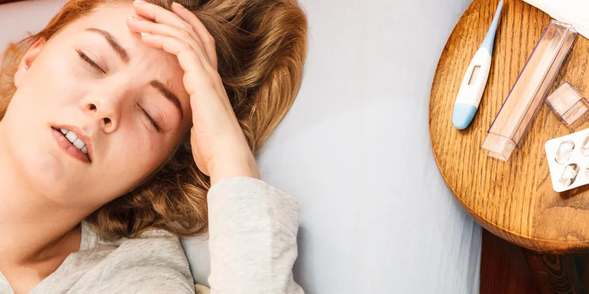 sick woman suffering from headache pain ill girl laying in bed caught cold thermometer and pills on table sick woman suffering from headache pain ill girl laying in bed caught cold thermometer and pills on table