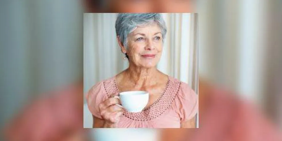 une femme senior avec une tasse de café en regardant loin et souriant une femme senior avec une tasse de café en regardant loin et souriant