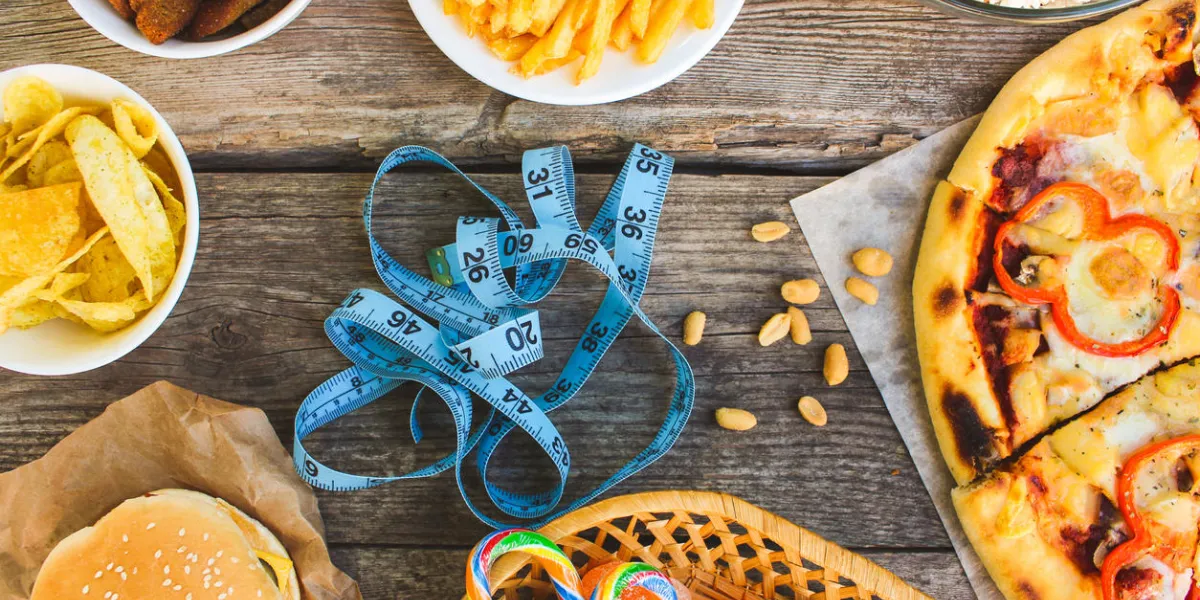 fast food, tape measure on old wooden background concept of junk eating toned image top view fast food, tape measure on old wooden background concept of junk eating toned image top view