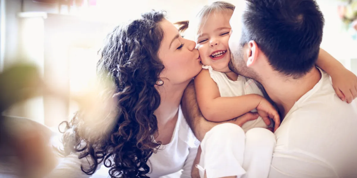 mom and dad's love happy family together in bed close up