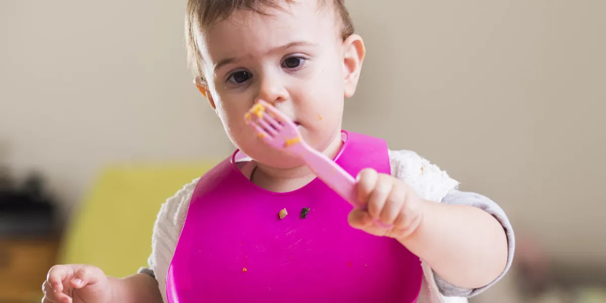 mignonne petite fille mangeant avec une fourchette rose mignonne petite fille mangeant avec une fourchette rose